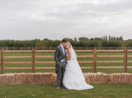 Bride and groom posing for a wedding photo at Norton Common Farm