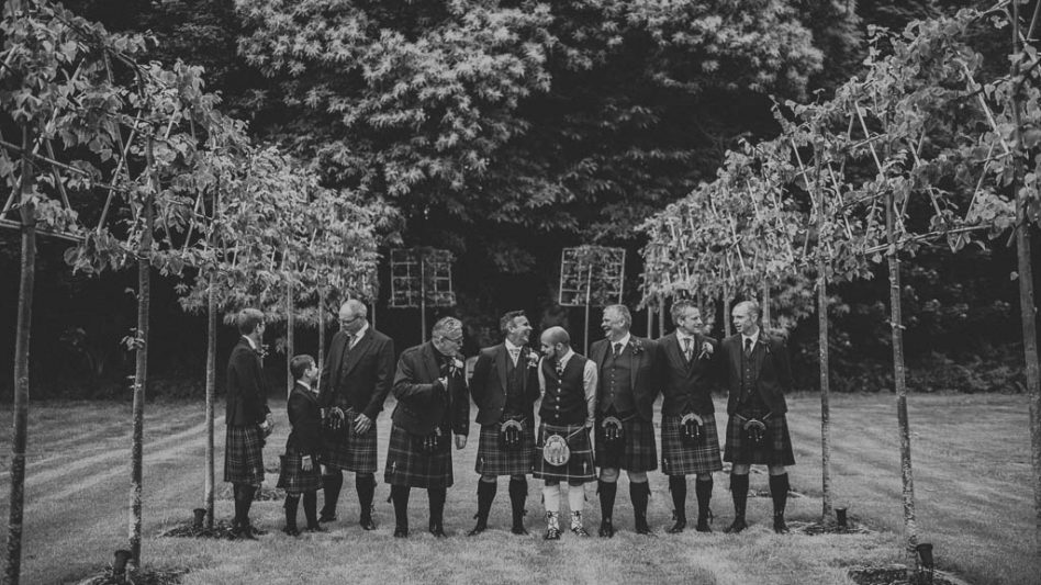 Groom and best men in Scottish kilts photographed outside Hazel Gap Barn