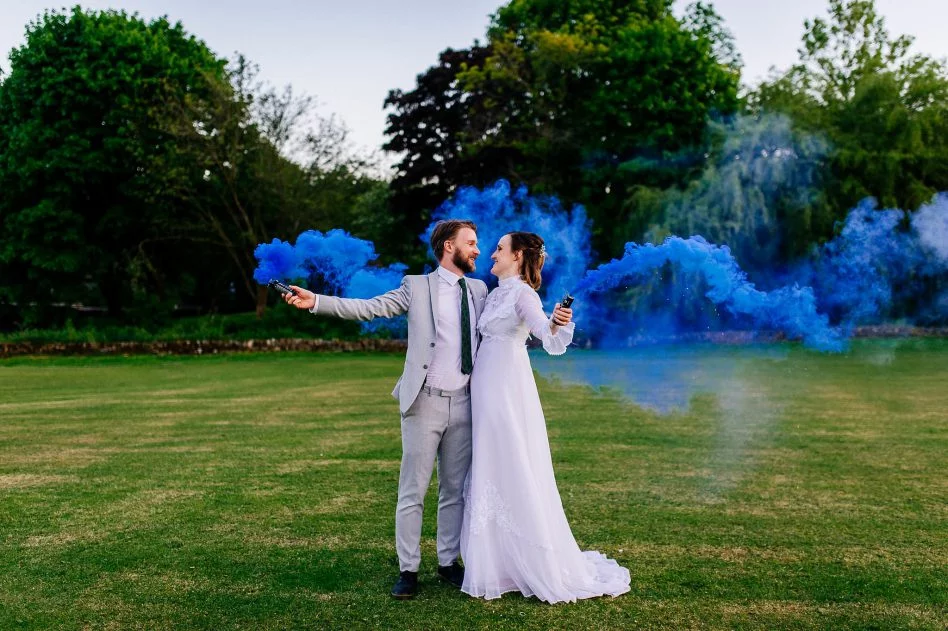 Bride and groom holding smoke bombs