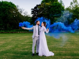 Bride and groom holding smoke bombs