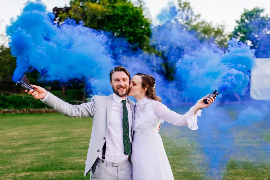 Bride and groom with blue smoke bombs