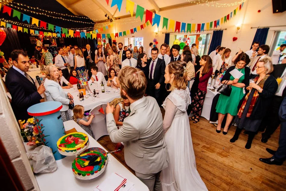Bride and groom cutting wedding cake at Bradfield Village Hall