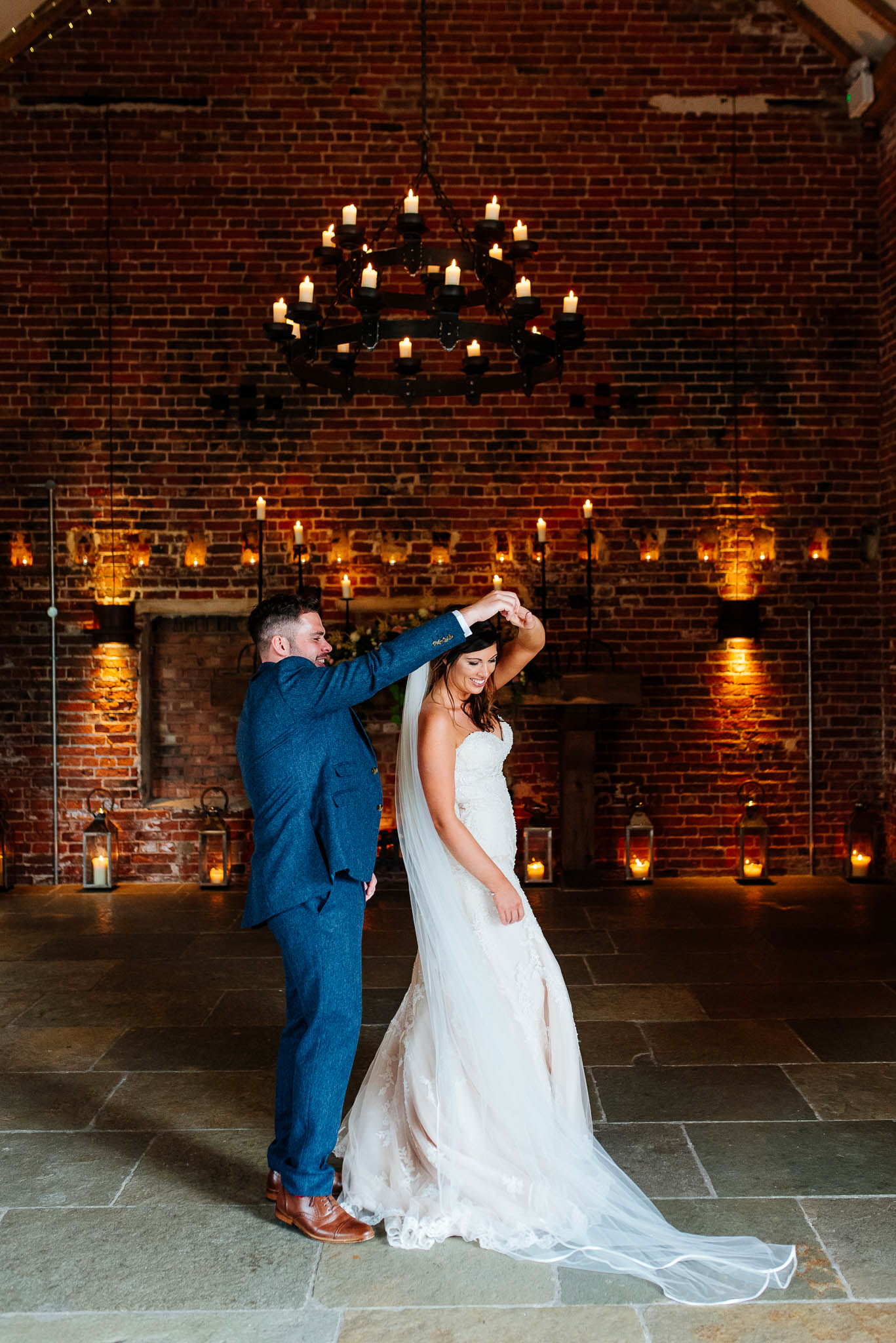 Bride and groom twirl in the main barn lit with candles.