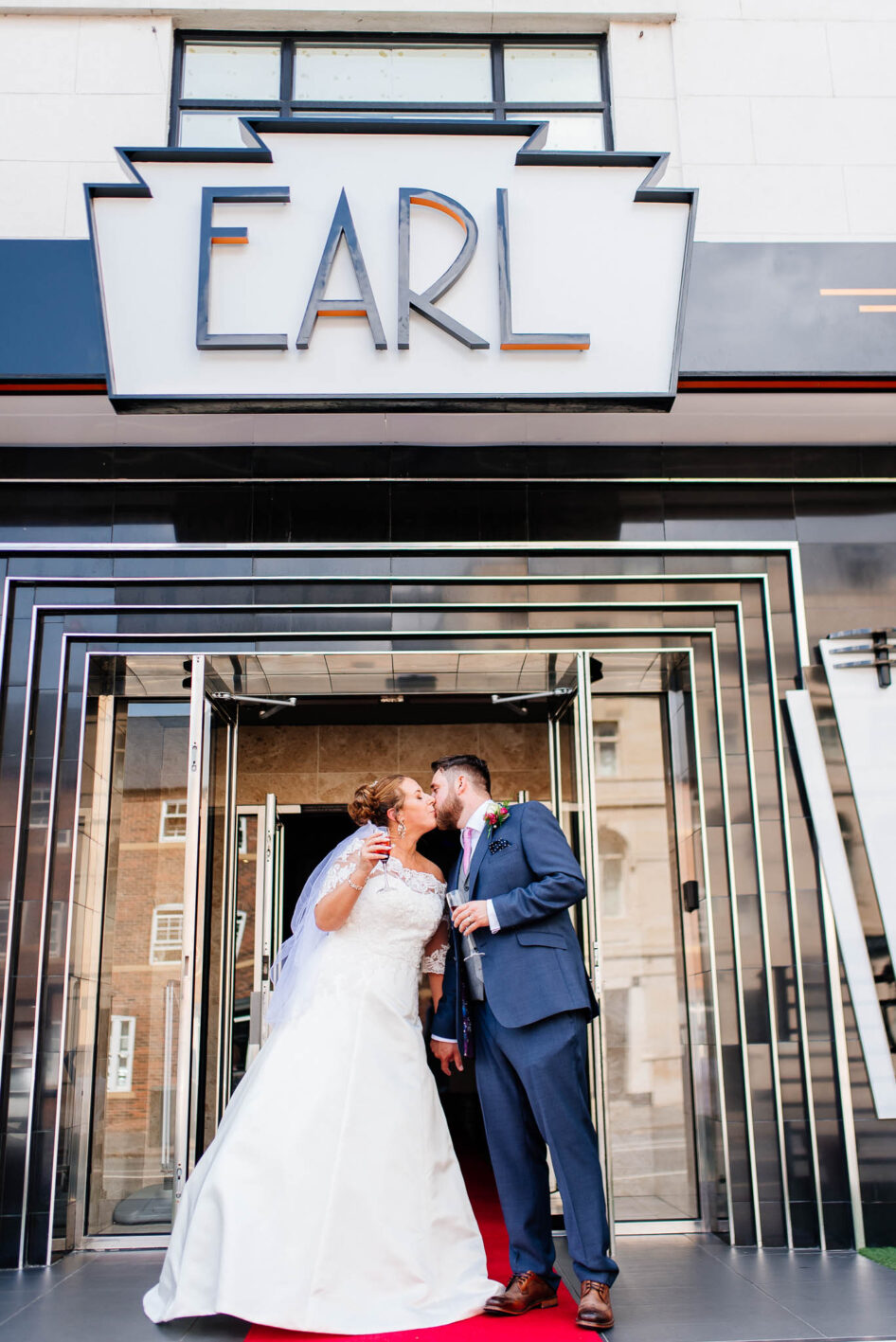 Bride and groom kissing on the main stairs outside the main entrance to The Earl Of Doncaster Hotel.