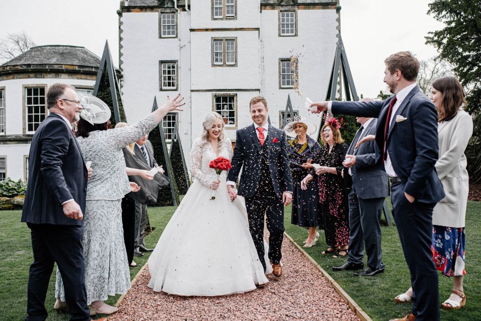 Bride and groom's exit during a confetti throw, Edinburgh wedding photography.